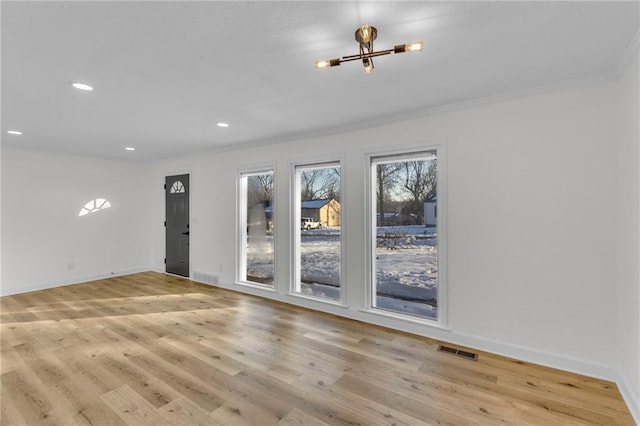 spare room with light hardwood / wood-style floors and ornamental molding