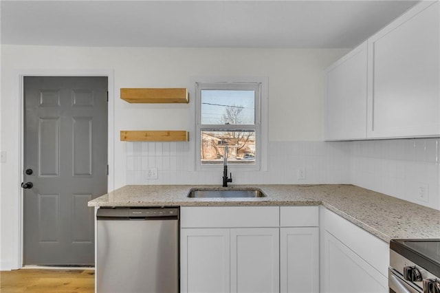 kitchen featuring sink, white cabinetry, light hardwood / wood-style flooring, stainless steel appliances, and light stone counters