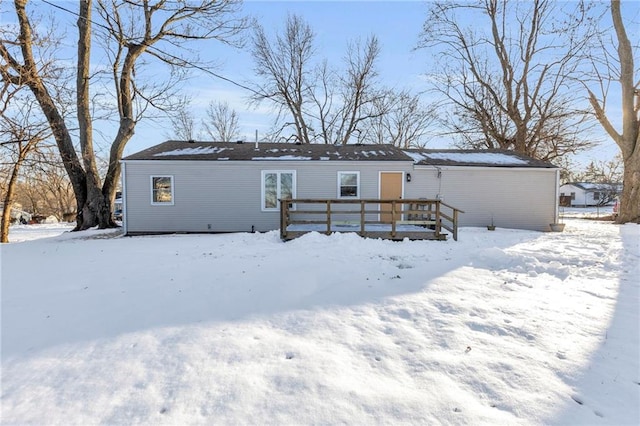 snow covered house featuring a deck