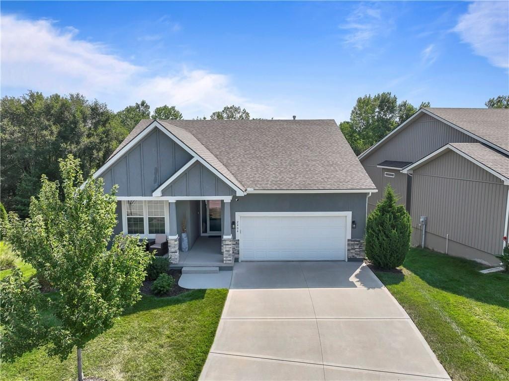 view of front of home featuring a garage, a porch, and a front yard