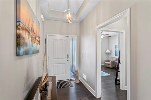 foyer entrance with ceiling fan, a tray ceiling, and dark hardwood / wood-style floors