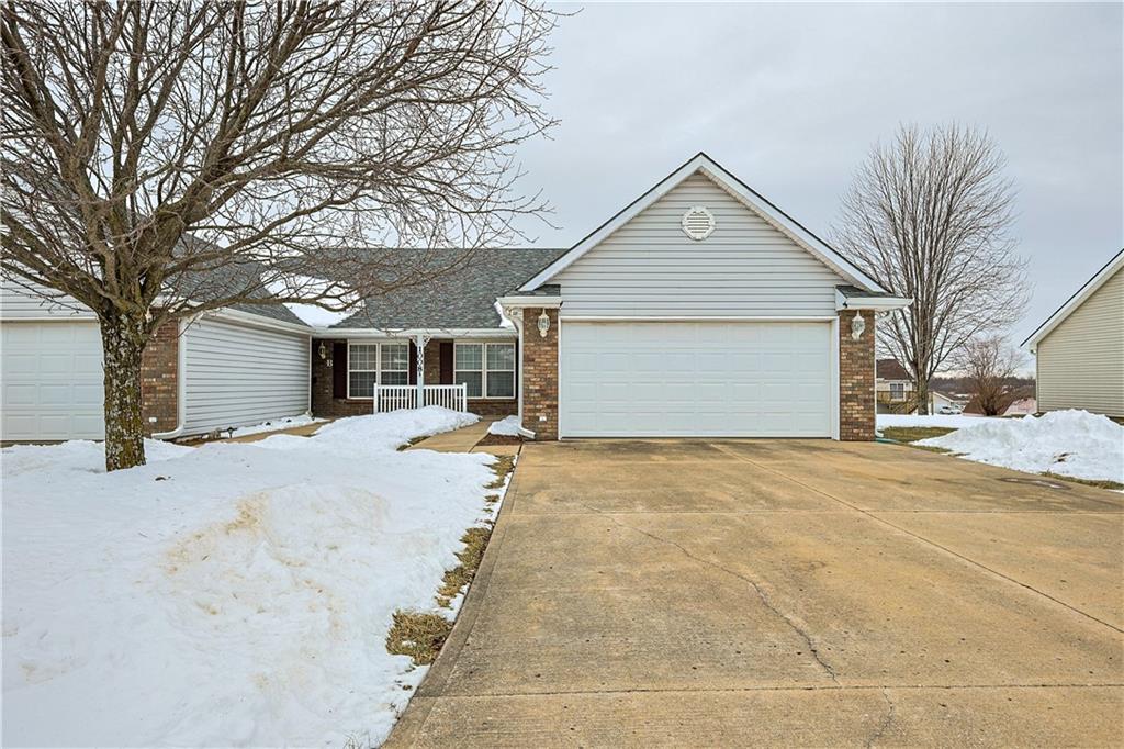 single story home featuring a porch and a garage