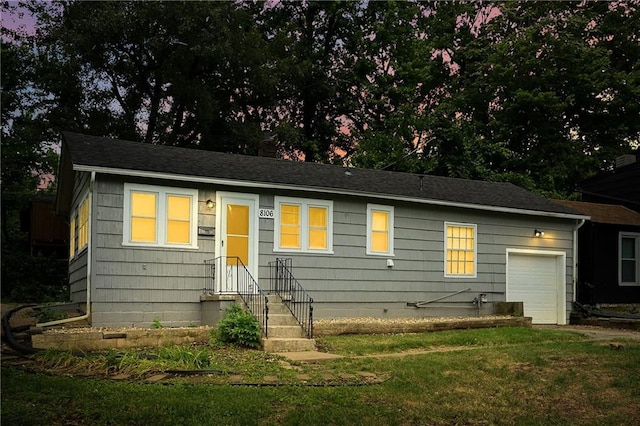 view of front of property with a garage and a front lawn