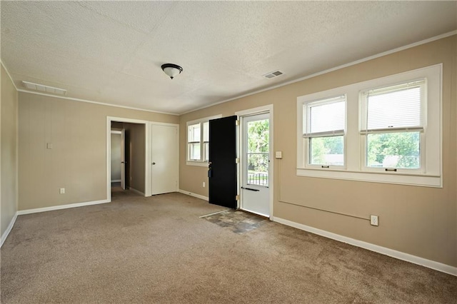 carpeted spare room featuring a textured ceiling and crown molding