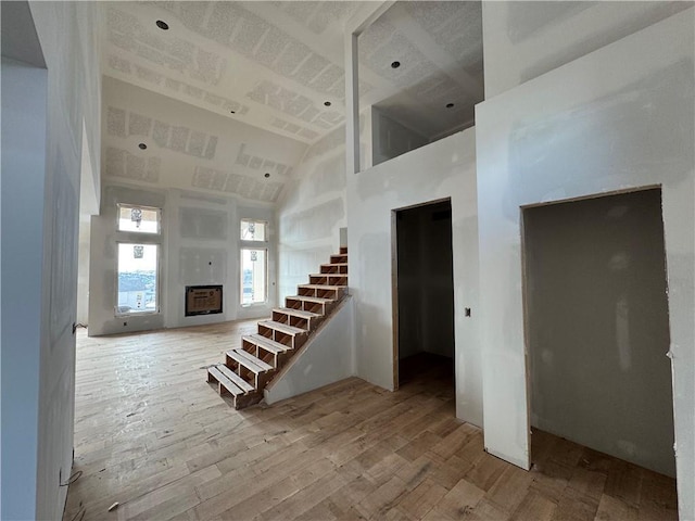 interior space with hardwood / wood-style flooring and high vaulted ceiling