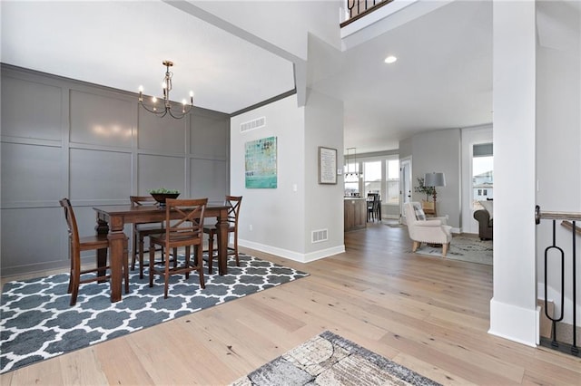 dining space featuring a notable chandelier and light wood-type flooring