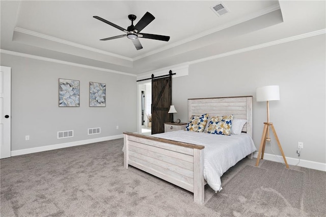 bedroom featuring ornamental molding, a barn door, a raised ceiling, and carpet floors