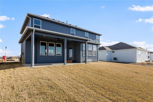 back of property featuring ceiling fan, a patio area, and a lawn