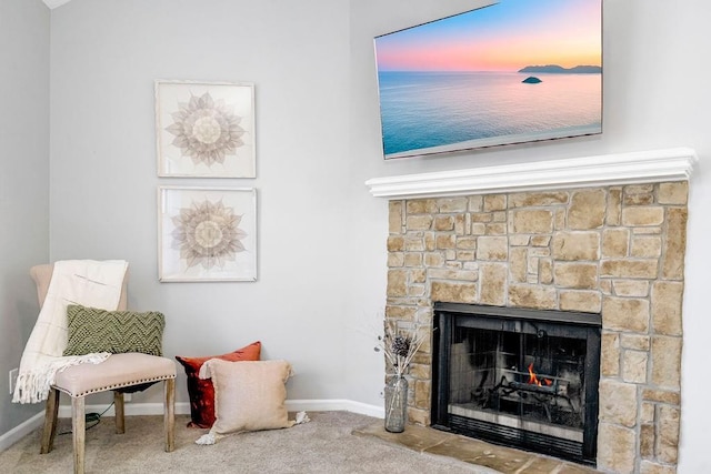 sitting room featuring carpet floors and a stone fireplace