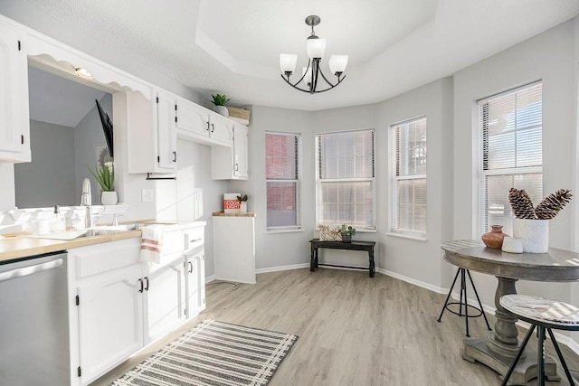 kitchen featuring an inviting chandelier, dishwasher, white cabinets, and decorative light fixtures