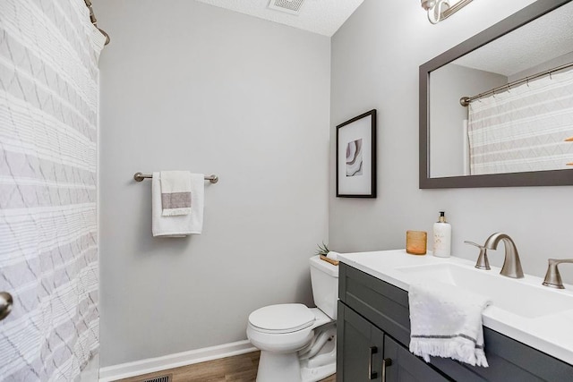 bathroom with toilet, wood-type flooring, and vanity