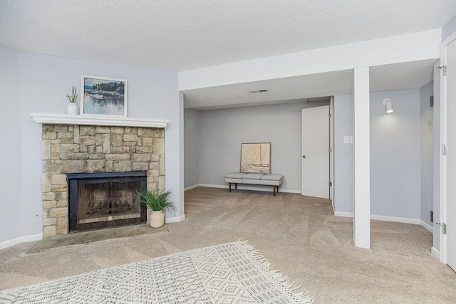 unfurnished living room featuring carpet floors, a textured ceiling, and a stone fireplace