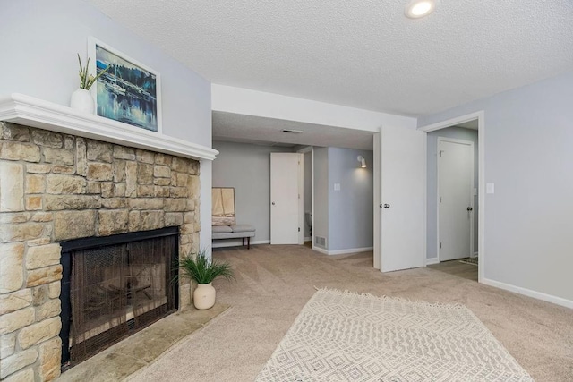 living room with a textured ceiling, light colored carpet, and a stone fireplace