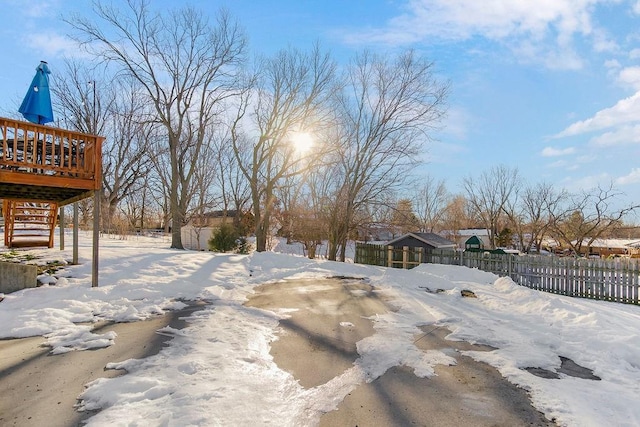 yard covered in snow featuring a deck