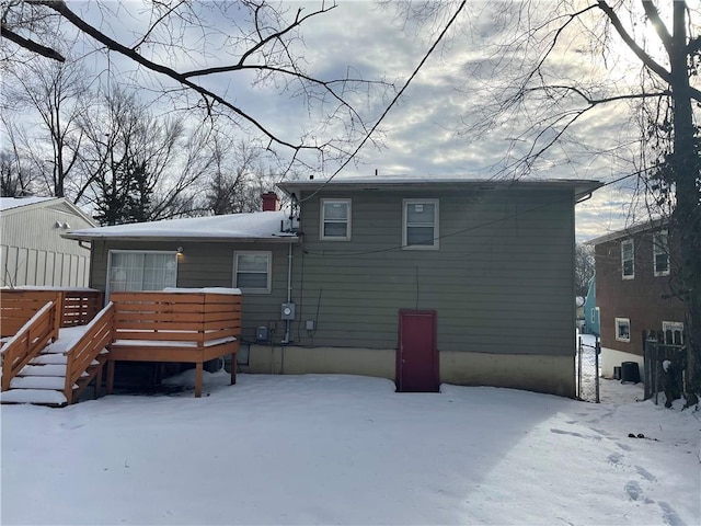 snow covered property with a deck