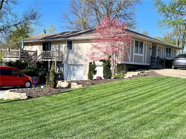 view of front of house featuring a garage, a front lawn, and a deck