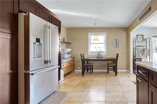 kitchen featuring light tile patterned flooring, pendant lighting, high end refrigerator, dark brown cabinets, and a textured ceiling