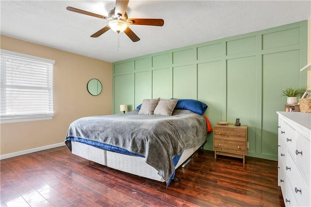 bedroom featuring dark wood-type flooring, ceiling fan, and a textured ceiling