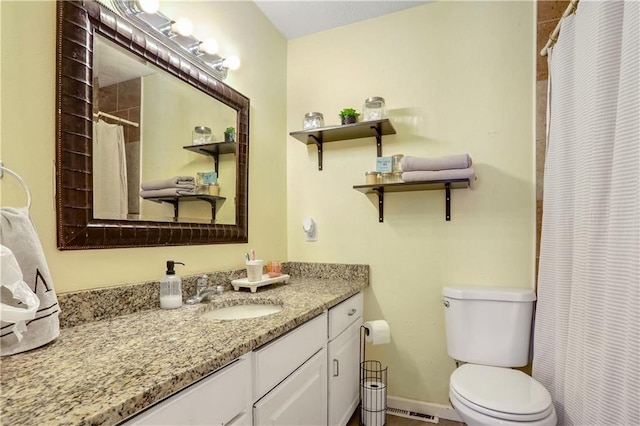 bathroom with walk in shower, vanity, and toilet