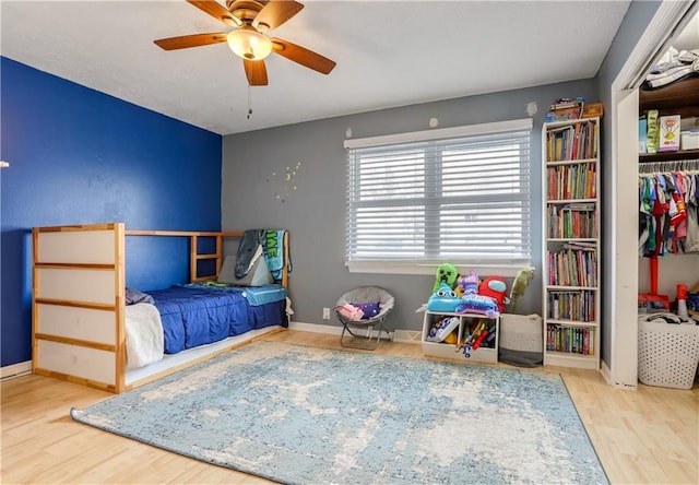 bedroom featuring hardwood / wood-style floors, a closet, and ceiling fan