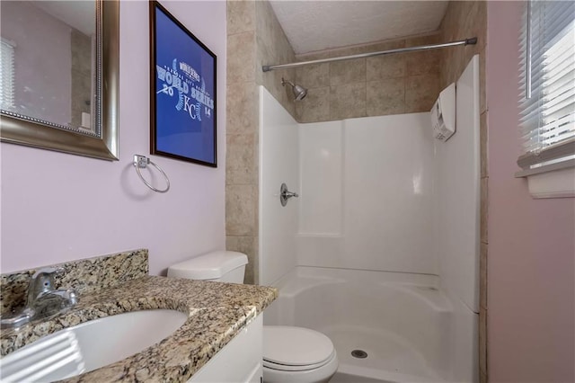 bathroom with vanity, a shower, and toilet