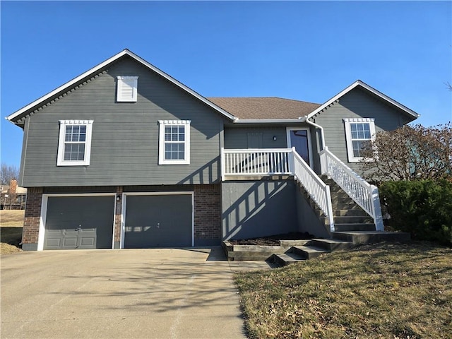 view of front facade with stairway, brick siding, a garage, and concrete driveway