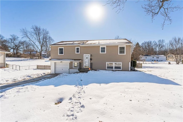 snow covered property featuring a garage