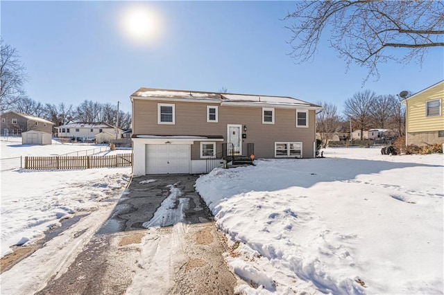 snow covered rear of property featuring a garage