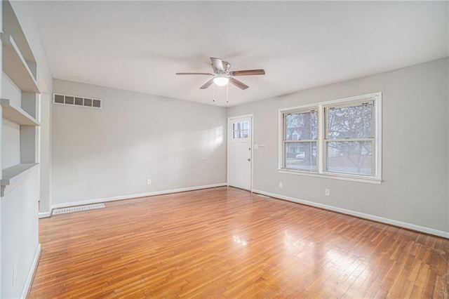 empty room with ceiling fan and light hardwood / wood-style floors