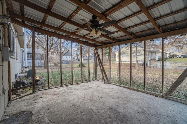 unfurnished sunroom featuring ceiling fan and a wealth of natural light