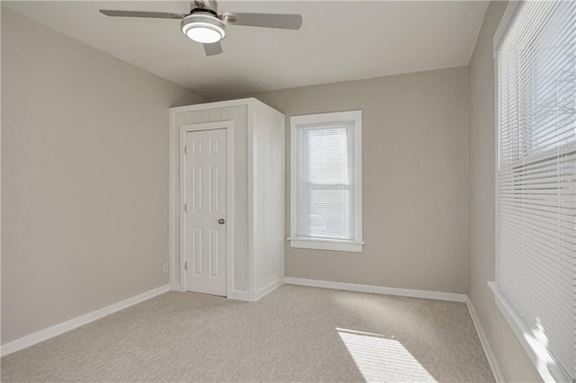 unfurnished bedroom with light carpet, ceiling fan, and a closet