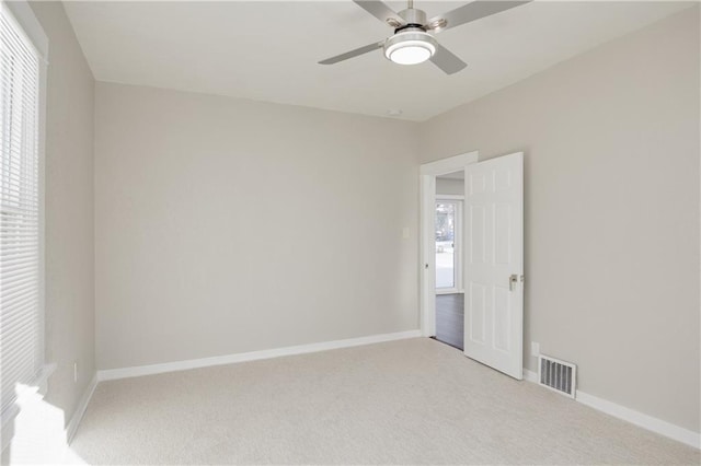 carpeted empty room featuring ceiling fan and a healthy amount of sunlight