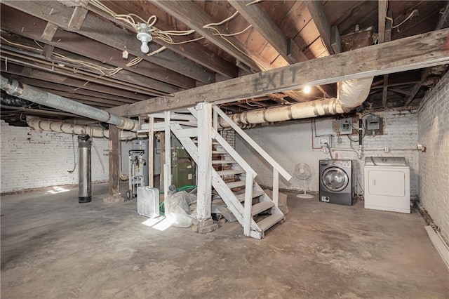 basement featuring washer and dryer and brick wall