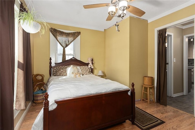 bedroom featuring ceiling fan, crown molding, and light hardwood / wood-style floors