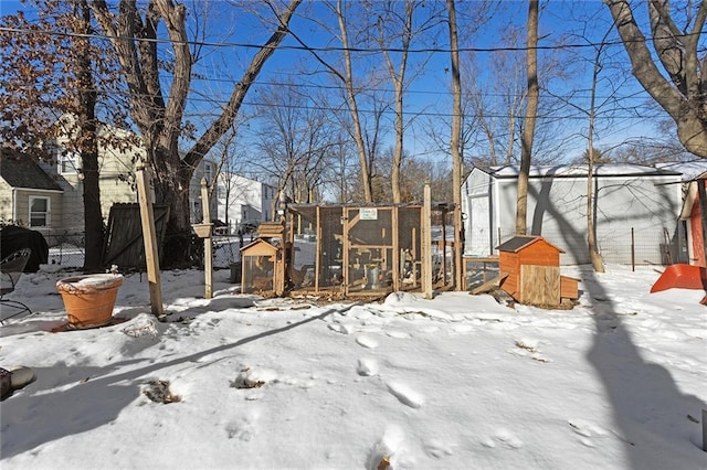 snowy yard with an outbuilding