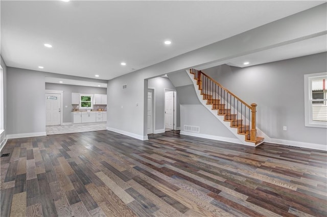 unfurnished living room with dark wood-type flooring