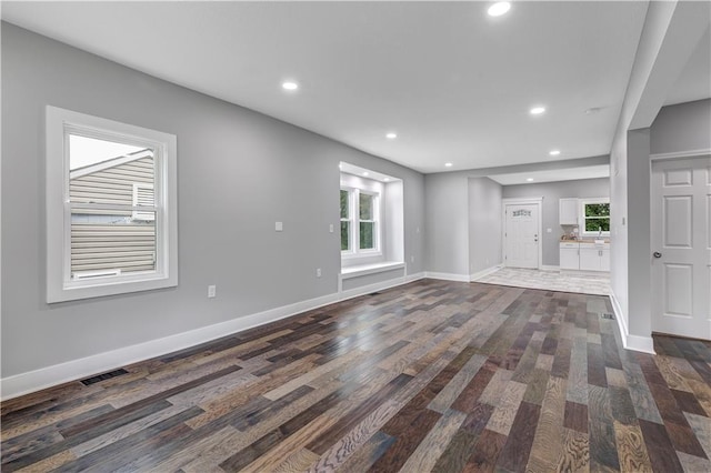 unfurnished living room with dark hardwood / wood-style flooring