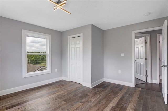 unfurnished bedroom with a closet and dark hardwood / wood-style floors