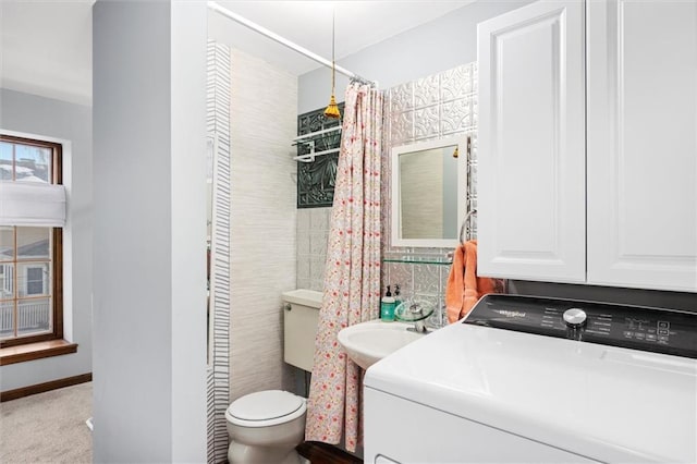 bathroom with sink, toilet, and washer / dryer