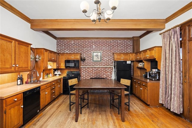 kitchen featuring light hardwood / wood-style floors, black appliances, sink, an inviting chandelier, and brick wall