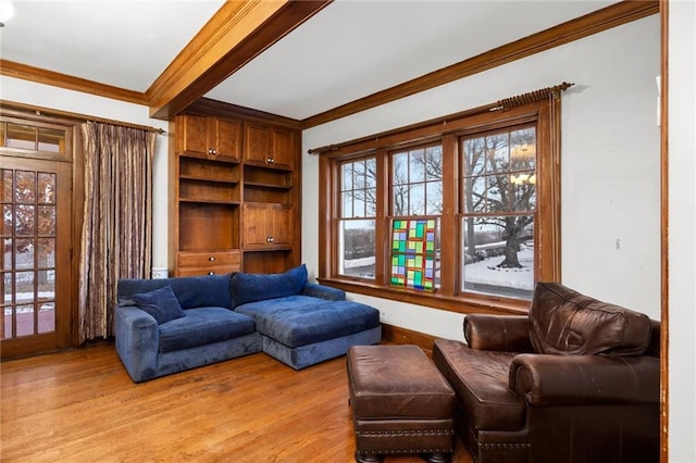 living room featuring beamed ceiling, crown molding, and light hardwood / wood-style floors