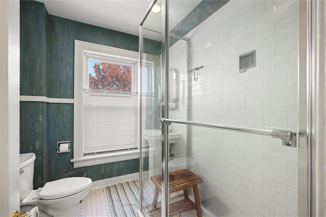 bathroom with toilet and a shower with shower door