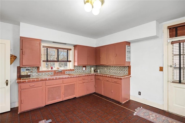 kitchen with tile counters, tasteful backsplash, and sink