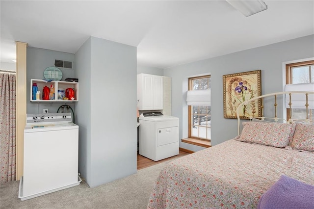 bedroom featuring light colored carpet and washer / dryer