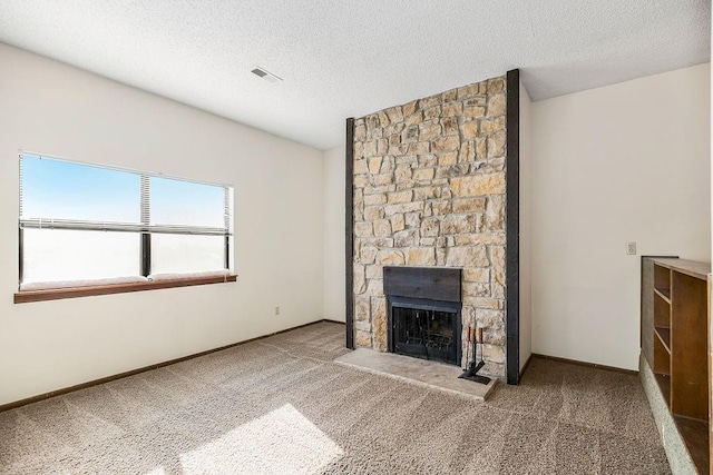 unfurnished living room featuring carpet floors, a textured ceiling, and a fireplace