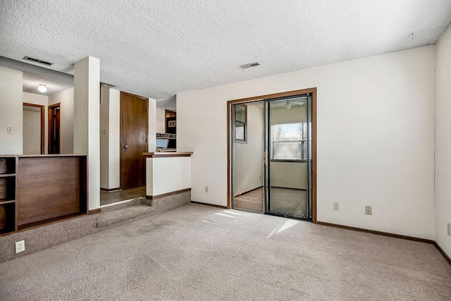 interior space featuring a textured ceiling and carpet floors