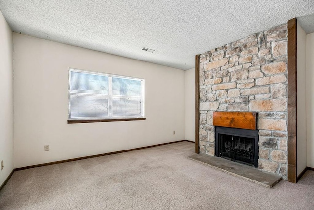 unfurnished living room with light carpet, a fireplace, and a textured ceiling