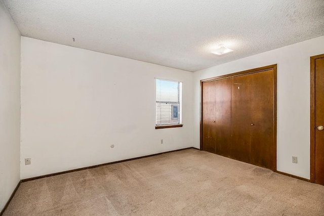 unfurnished bedroom featuring carpet, a closet, and a textured ceiling