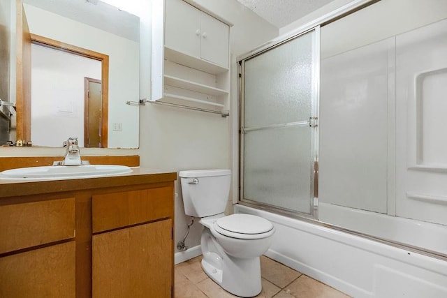 full bathroom with toilet, bath / shower combo with glass door, tile patterned flooring, a textured ceiling, and vanity