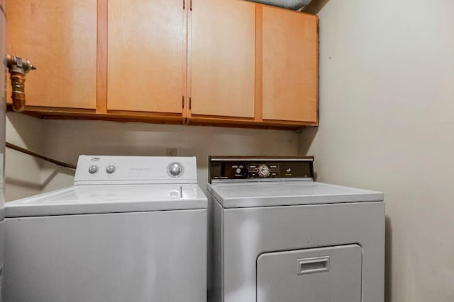 washroom featuring washing machine and clothes dryer and cabinets